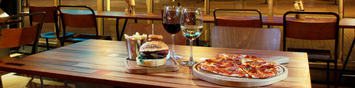 Clydebuilt restaurant. Burger, pizza, red wine, and white wine on table