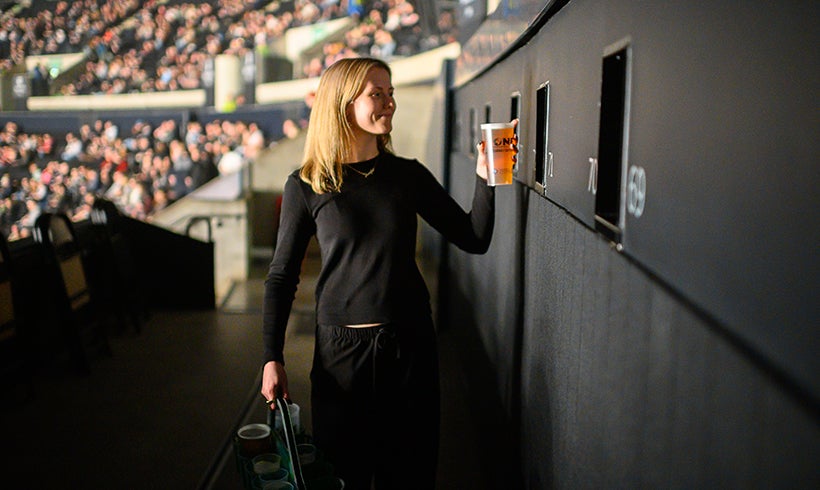 A woman delivering drinks at The Terrace Seats.