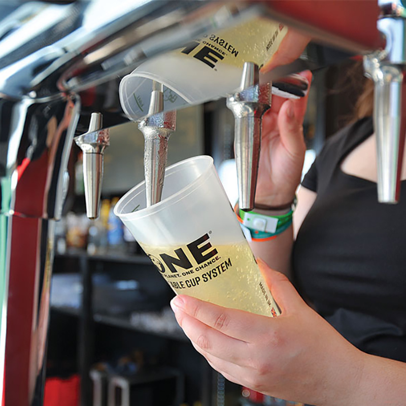 person pouring beer into a 'One Cup' from a beer tap