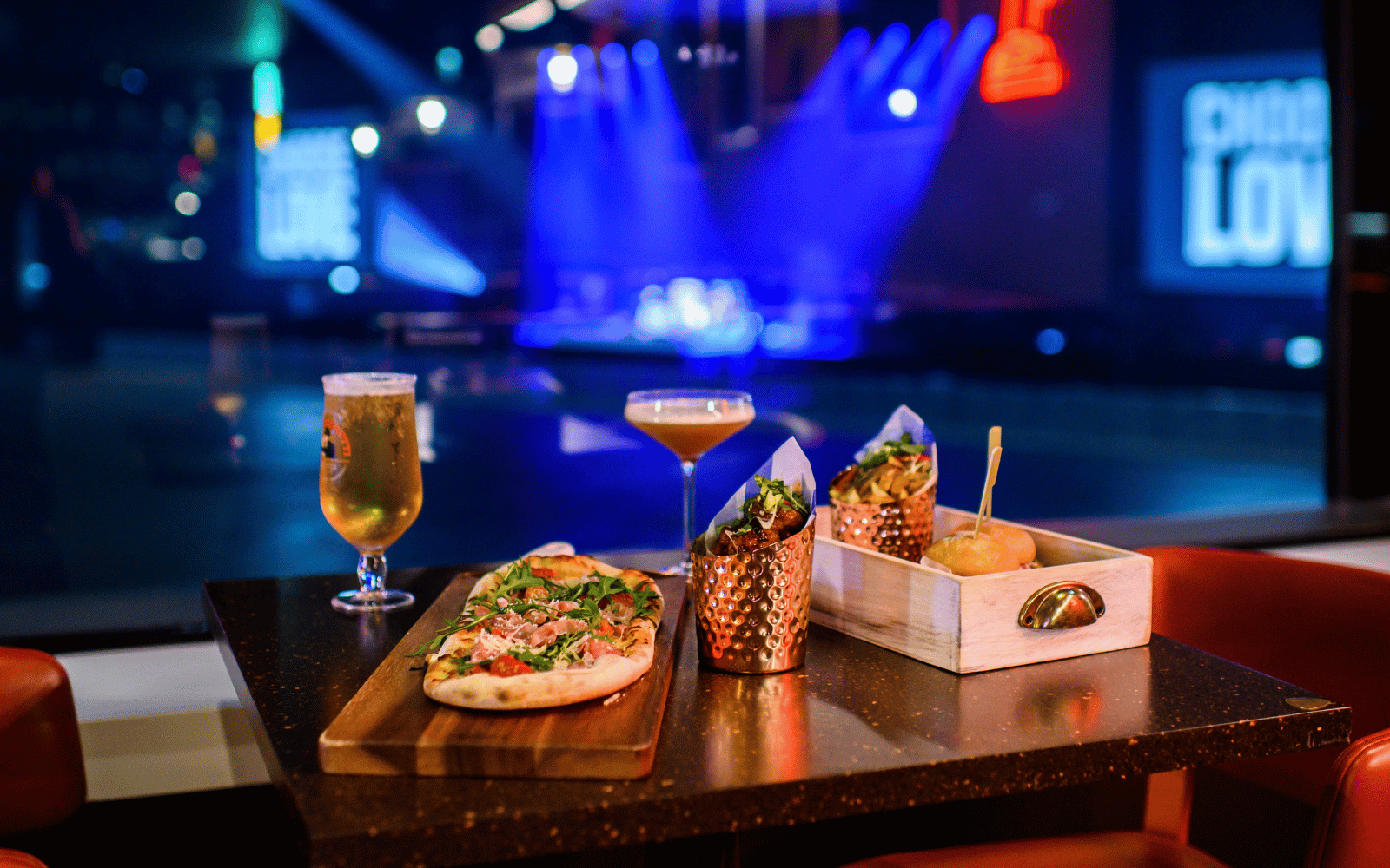 Burger, pizza, beer and cocktail in front of a view to the OVO Hydro stage.