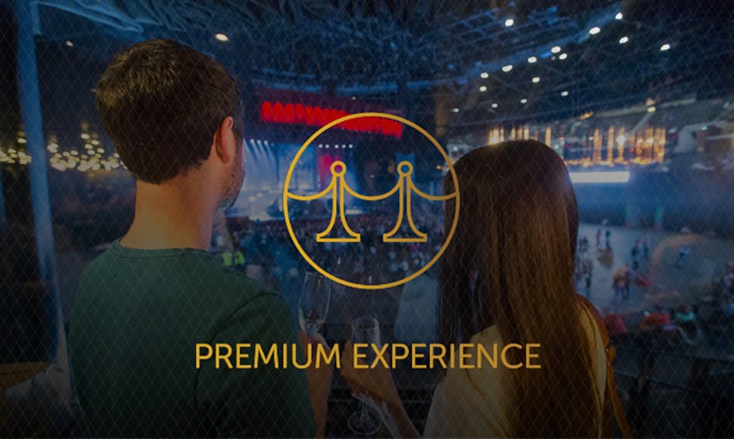 View from behind people looking onto stage with Premium Experience text and icon overlay.