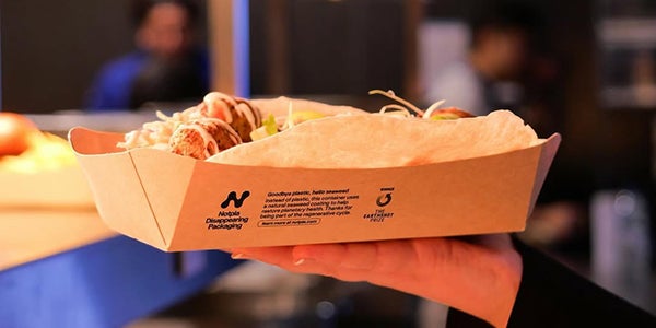 Someone holding Notpla packaging with food inside.